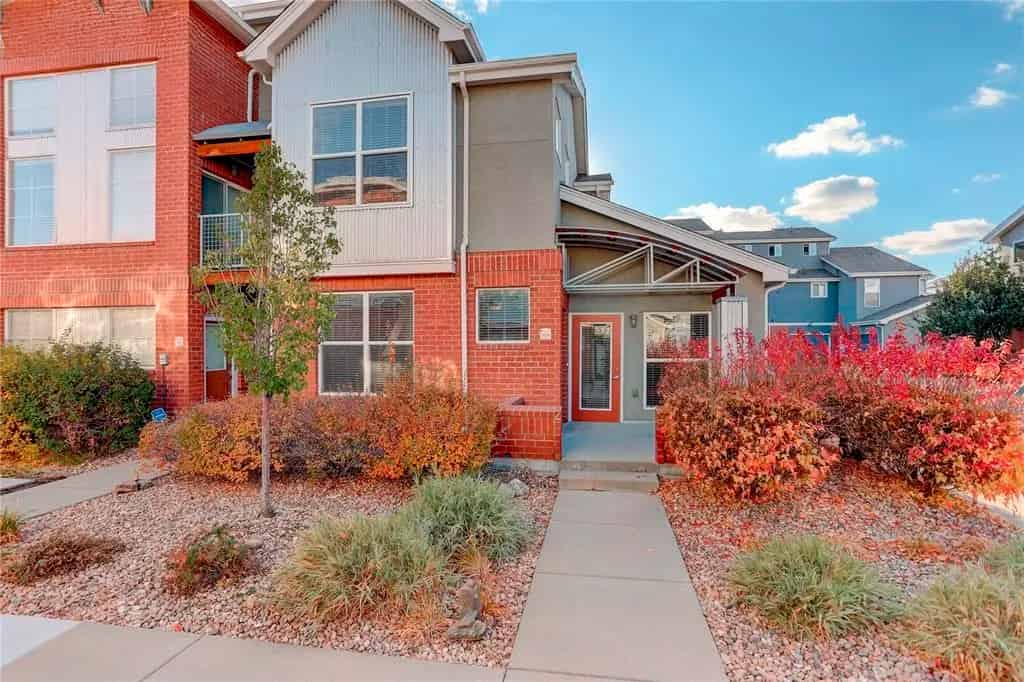 a brick building with a red front yard