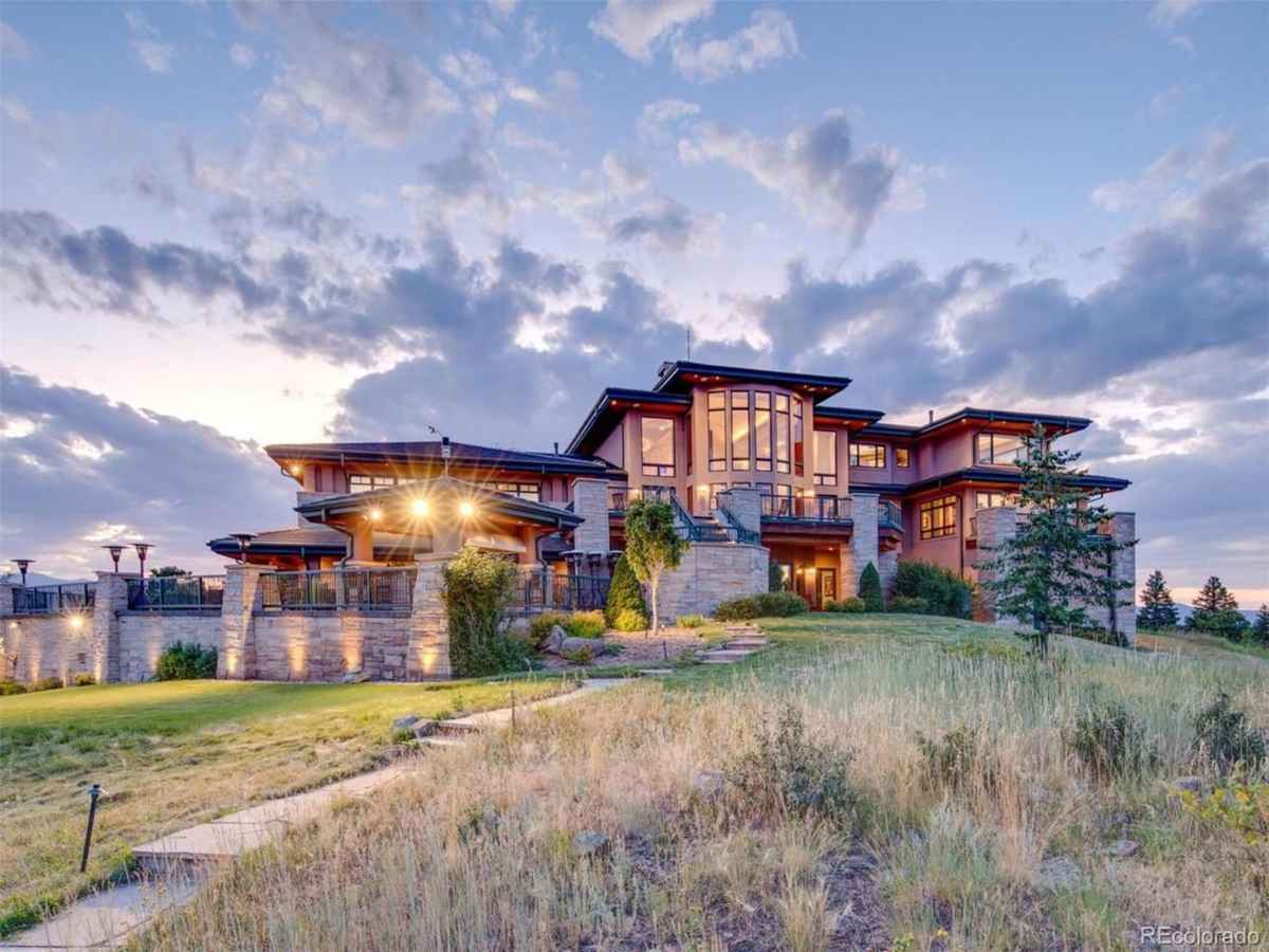 a large home with a large front yard and a grassy field