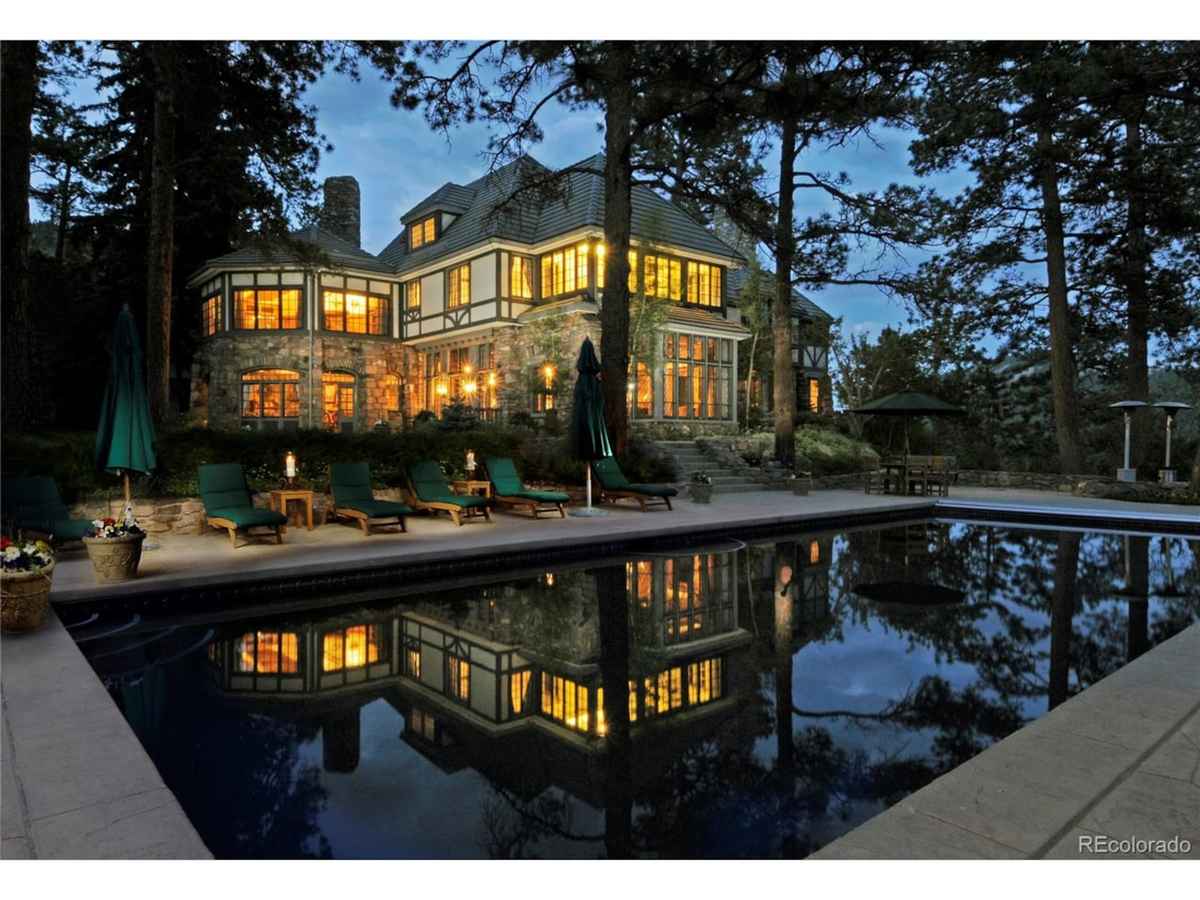 a large pool with a large house in the background