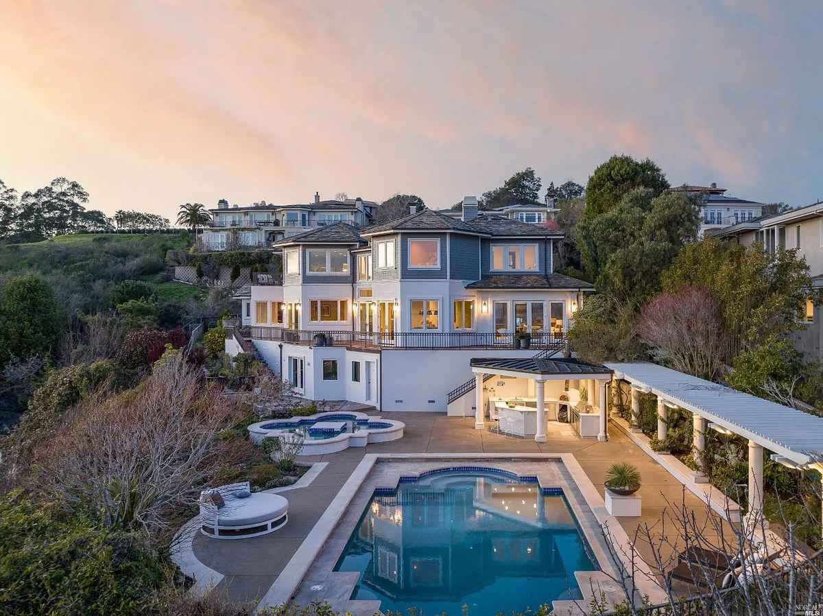 a large house with a pool and a large backyard area