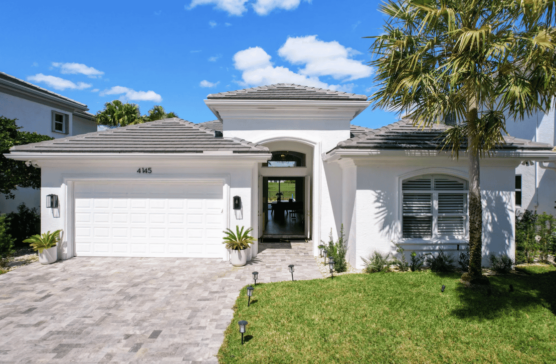 a white house with palm trees in the front yard