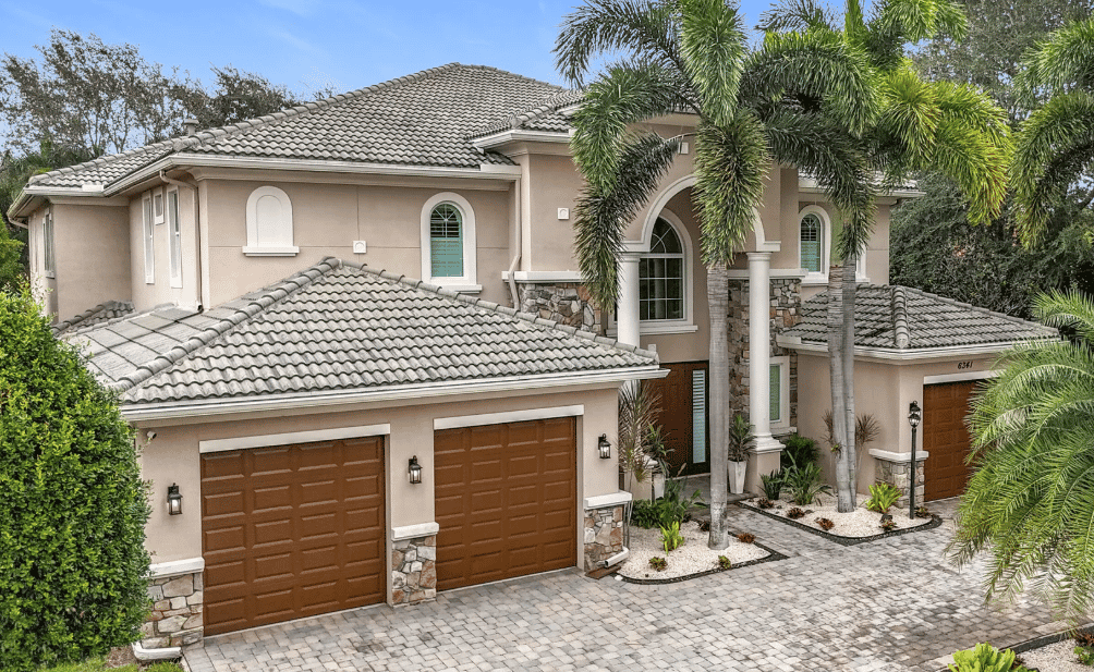a home with a driveway and palm trees