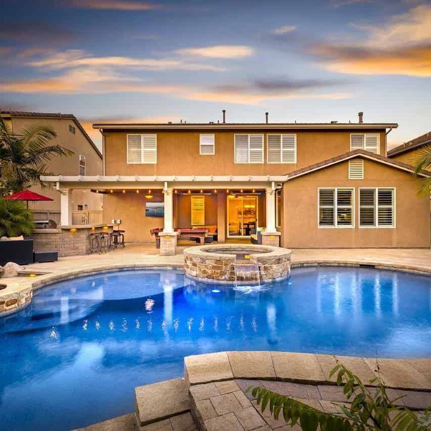 a pool with a hot tub and a fire pit