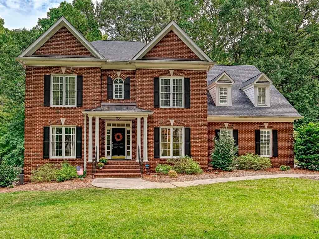 a brick house with black shutters and shutters