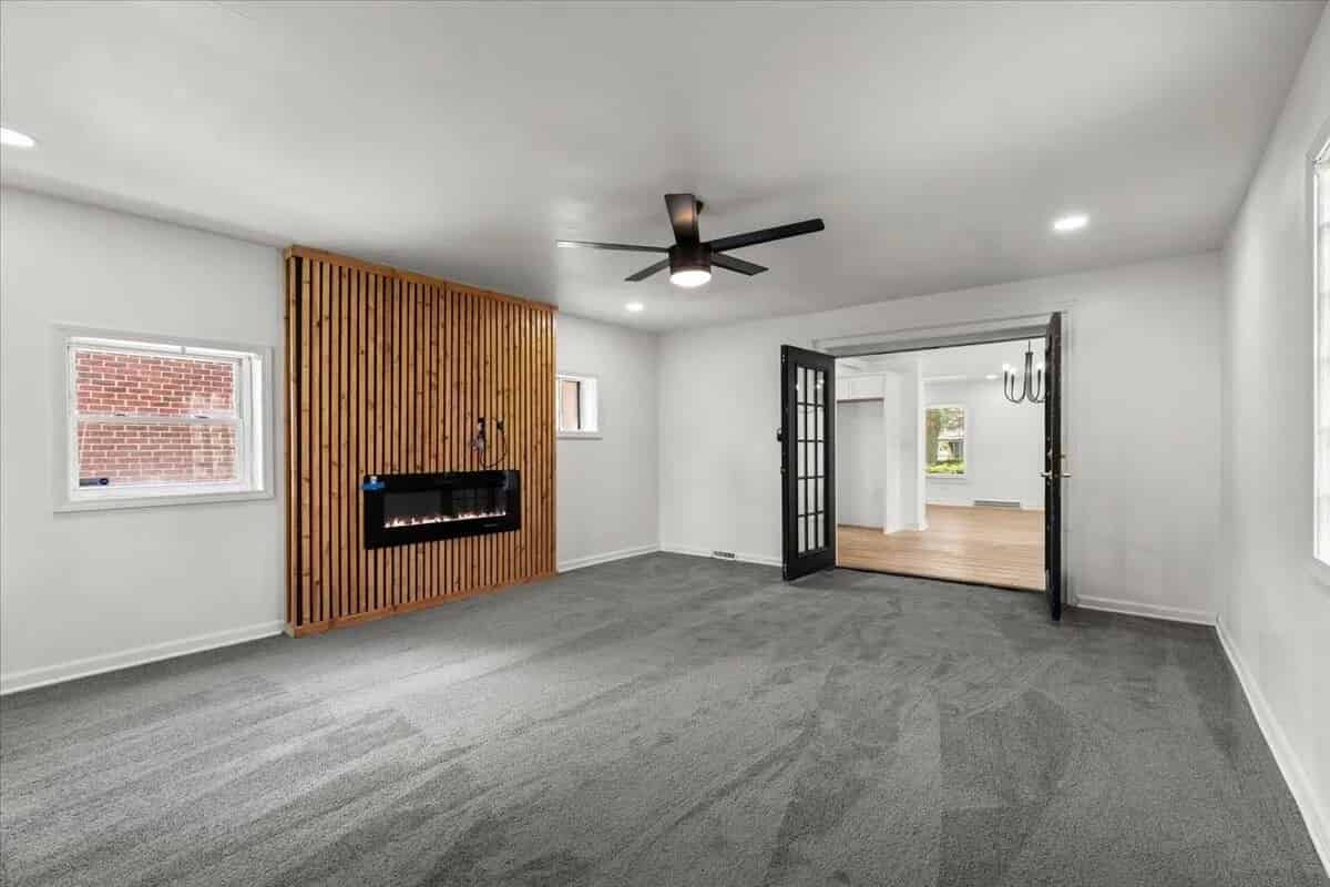 a living room with a large window and a large wooden floor