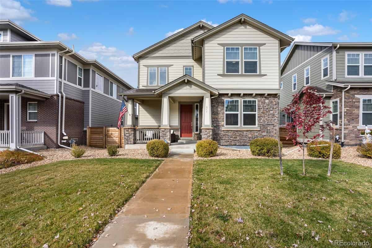 a two story house with a stone front yard and a sidewalk