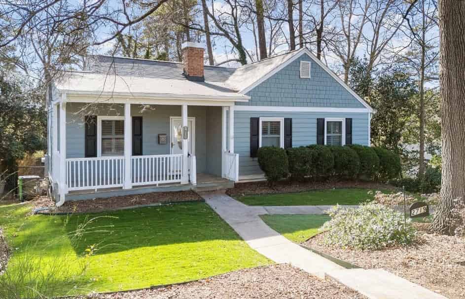 a blue house with white trim and a white porch