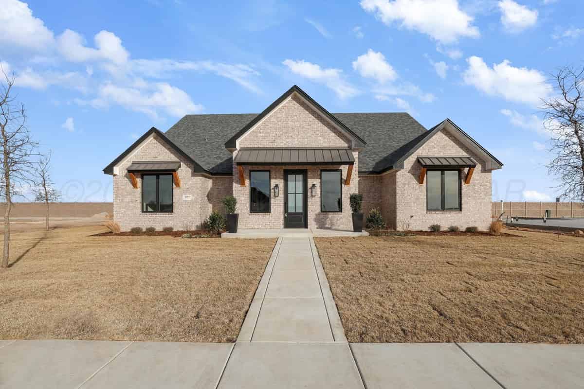 a brick home with a large front yard