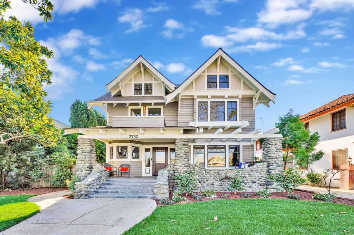 a house with a stone wall and a large yard