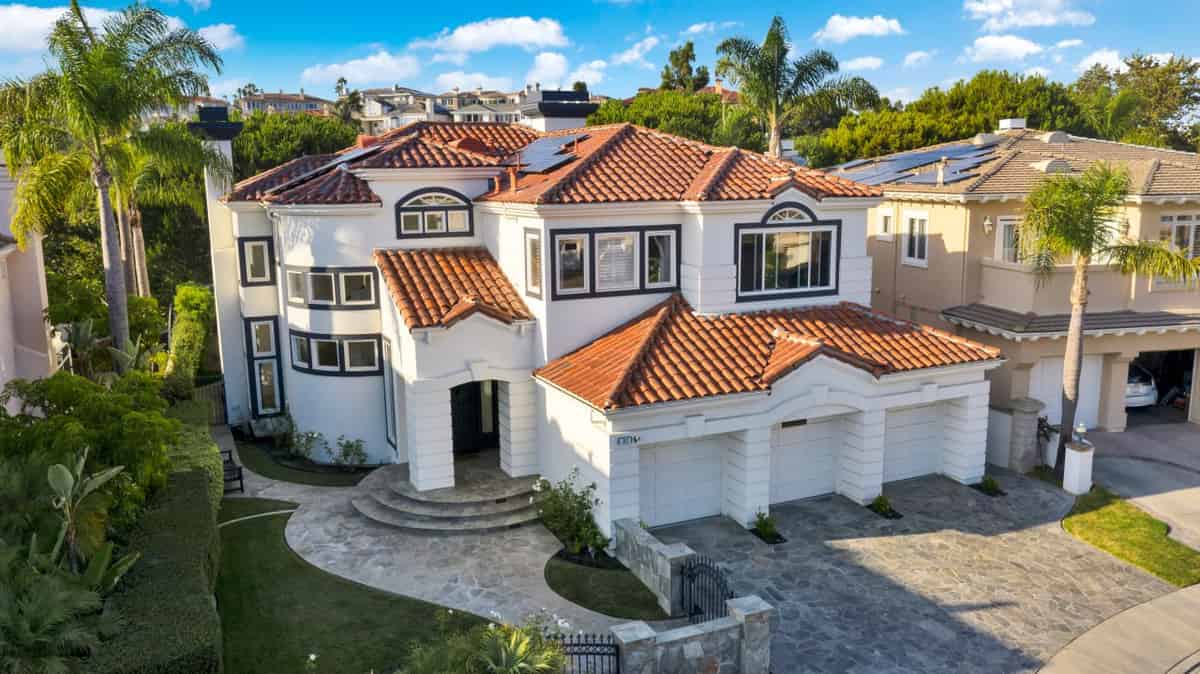 a home with a tiled roof and a large driveway