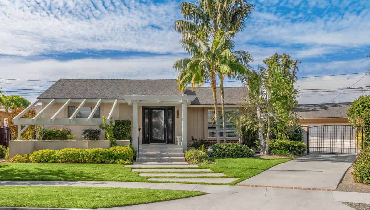 a home with a driveway and palm trees