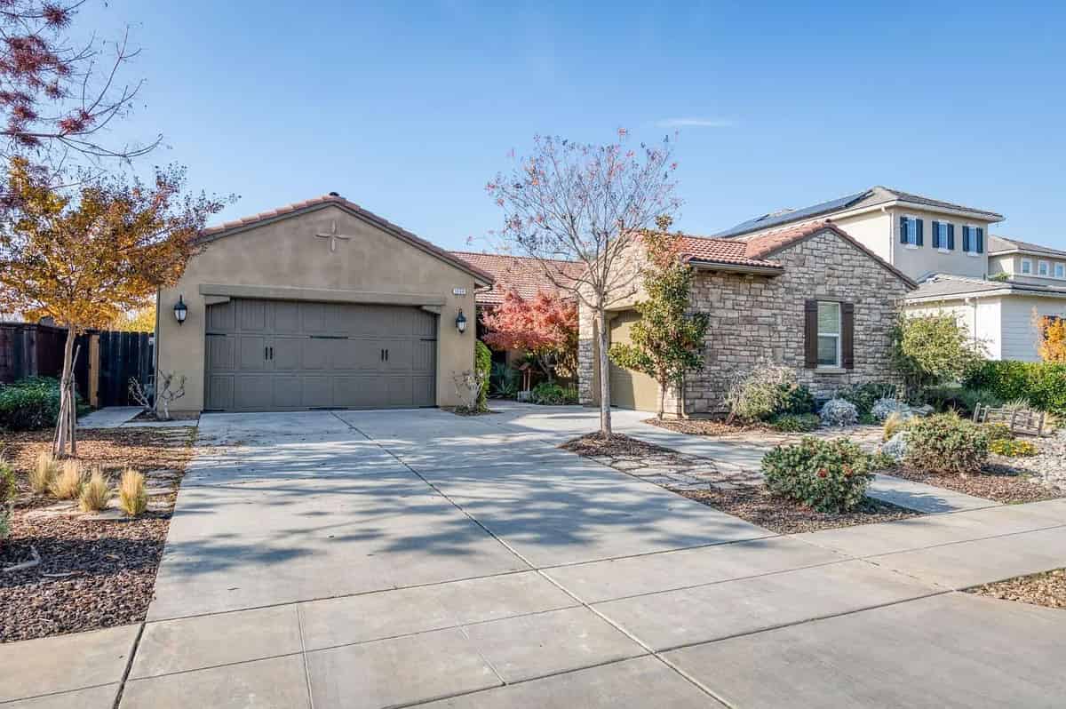 a home in the desert with a driveway and garage