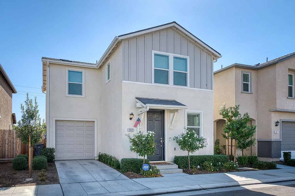 a two story house with a garage and garage door