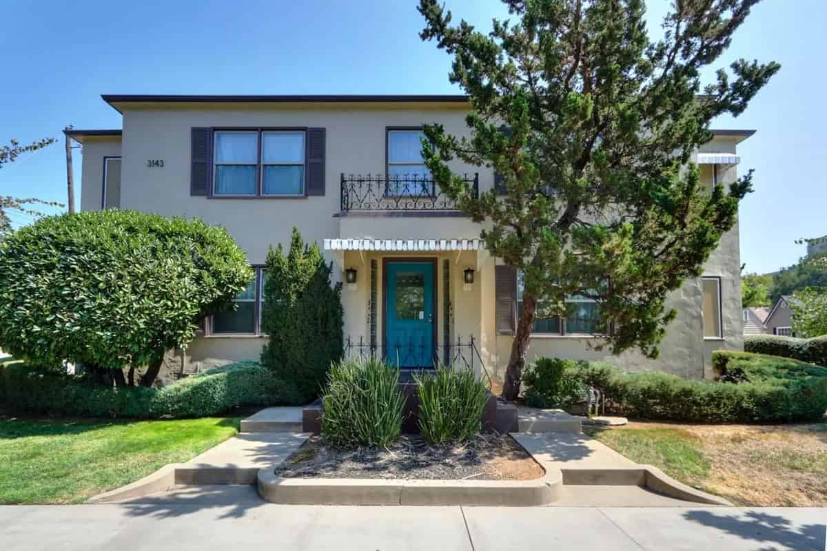 a house with a blue door and green trees