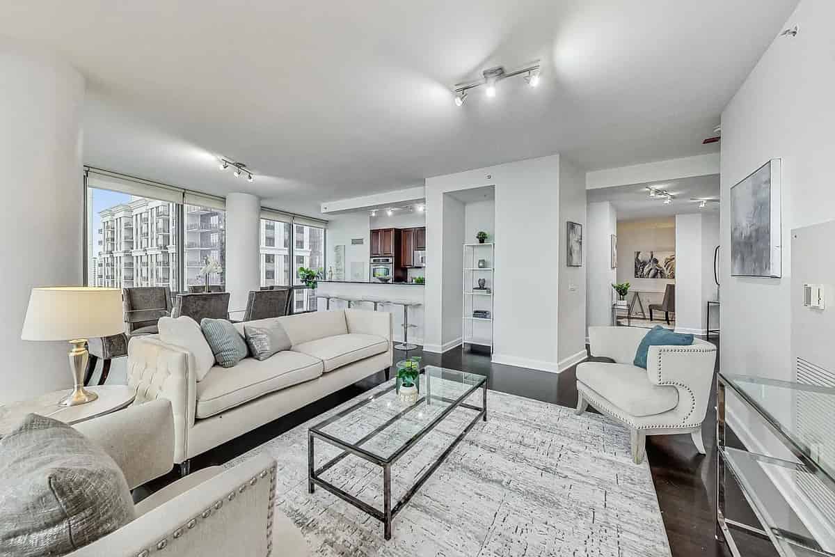 a living room with white furniture and a large window