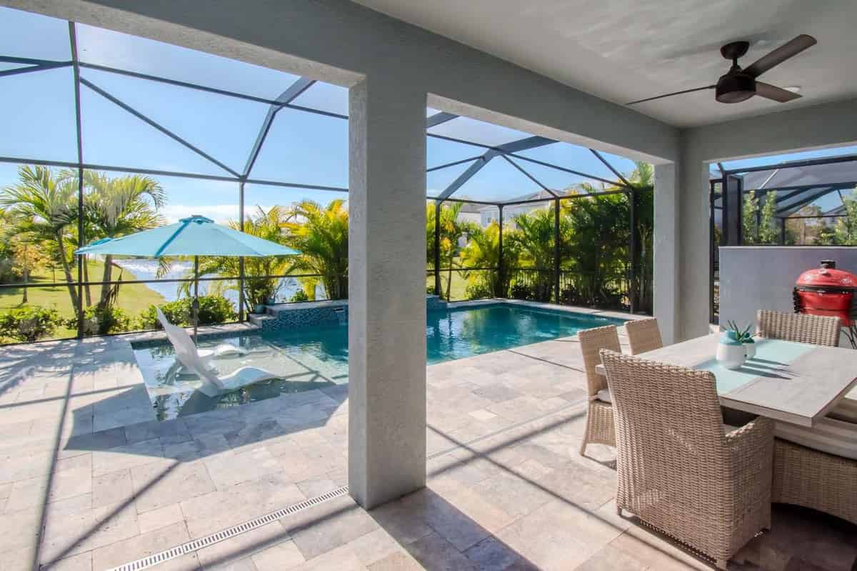a patio with a table and chairs and a pool