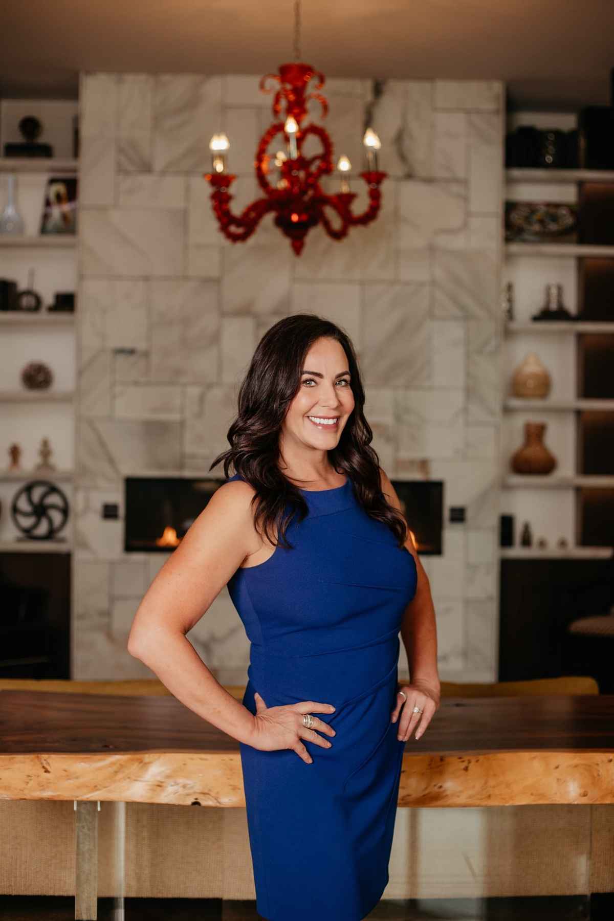 a woman in a blue dress standing at a table